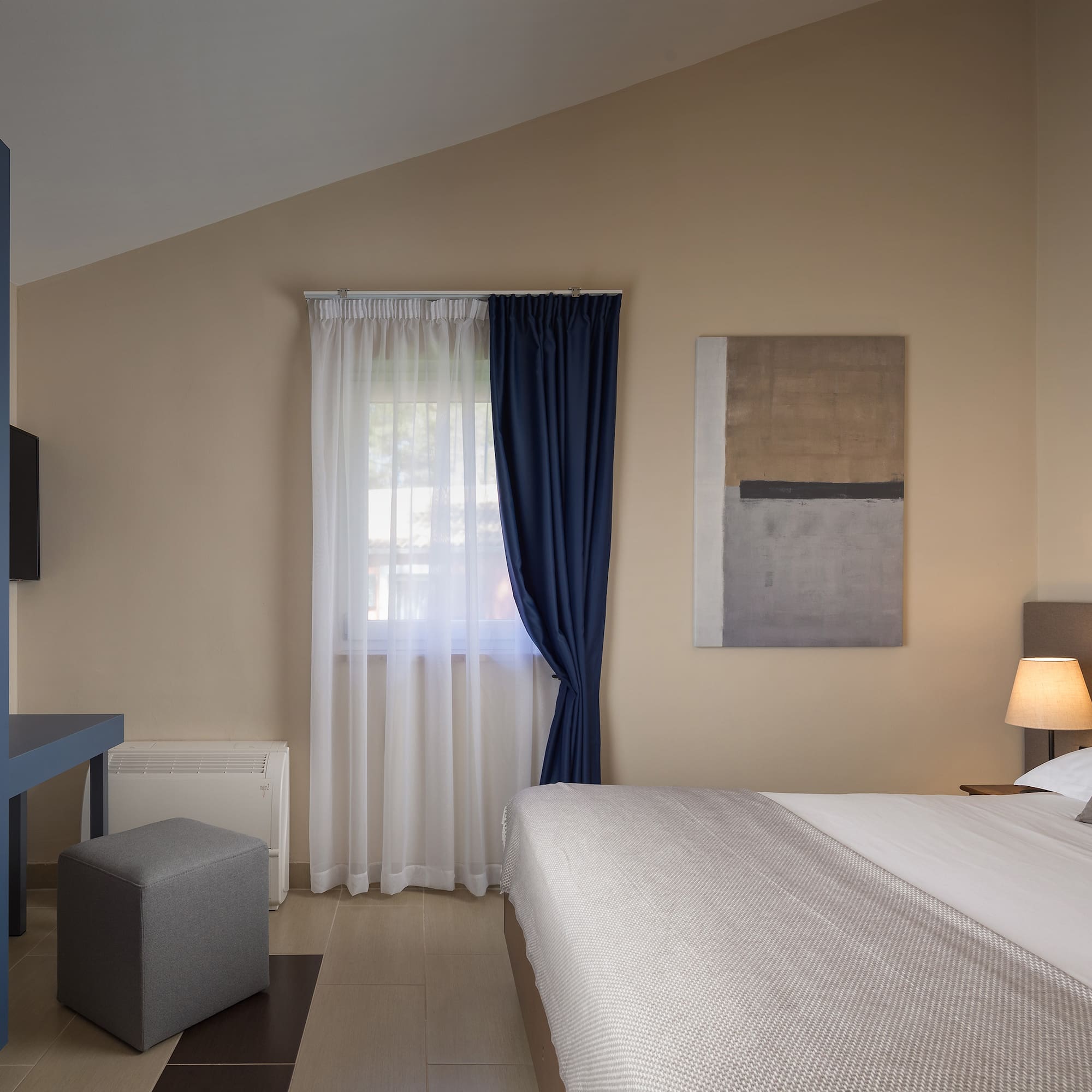 a bedroom with a bed and a blue curtain