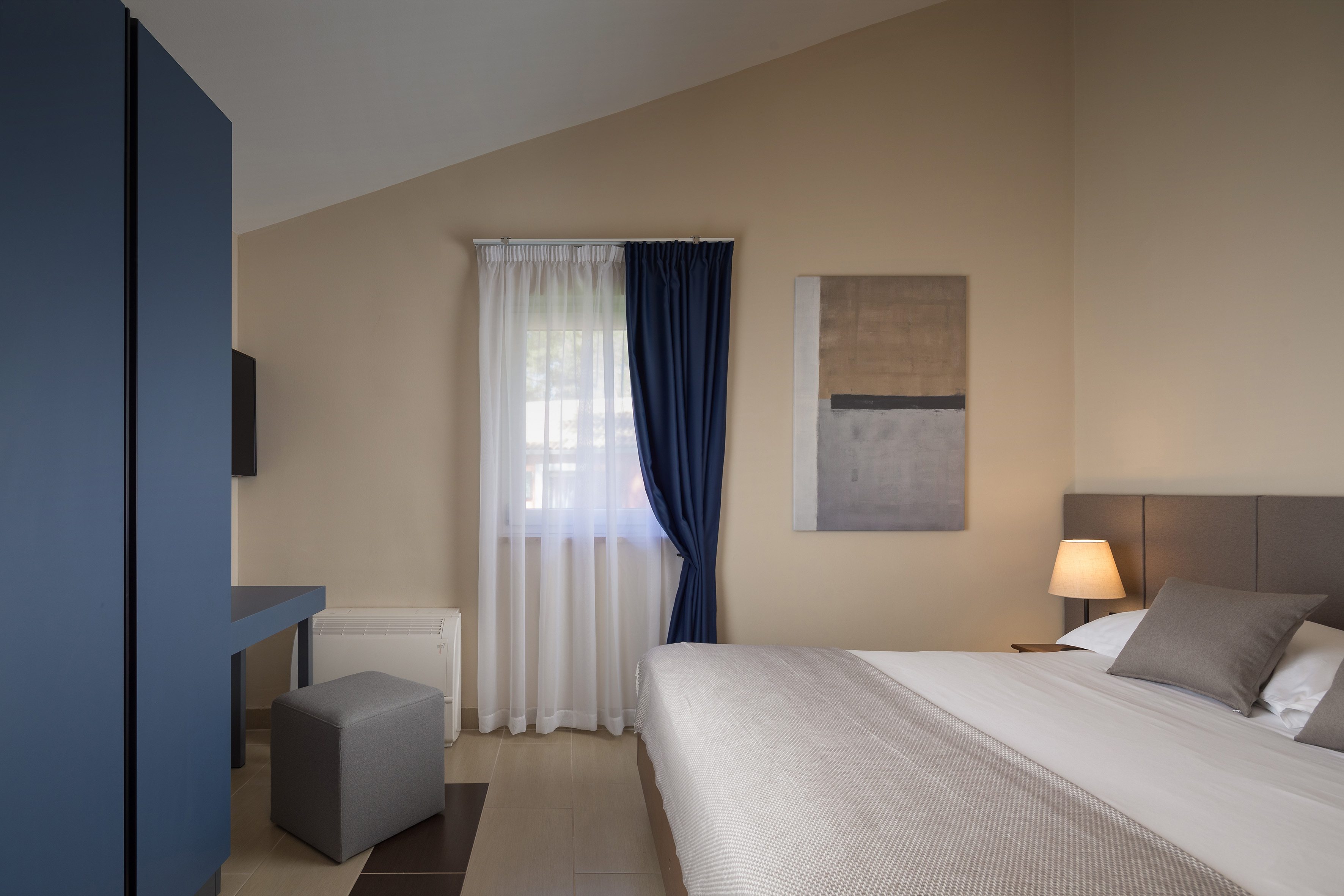 a bedroom with a bed and a blue curtain