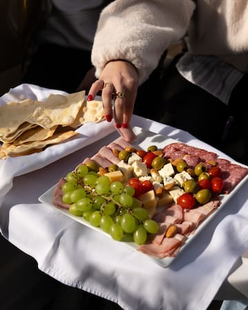 a person's hand reaching for a plate of food