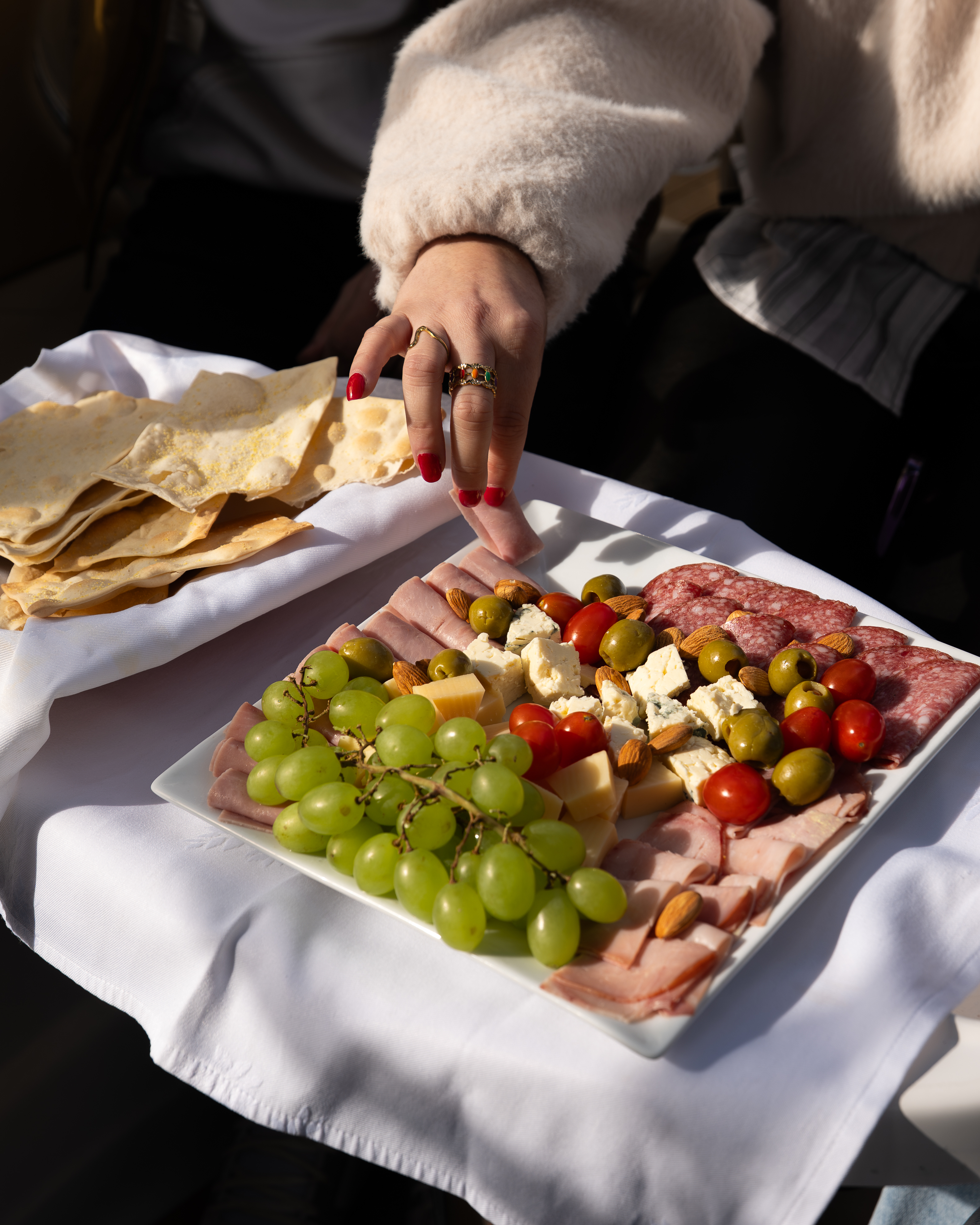 a person's hand reaching for a plate of food