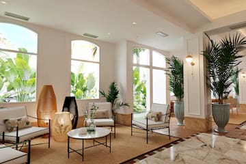 a room with white walls and white walls and a white floor with white chairs and a table with plants