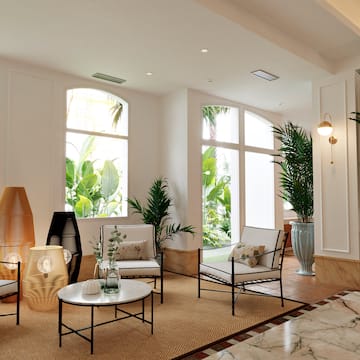 a room with white walls and white walls and a white floor with white chairs and a table with plants