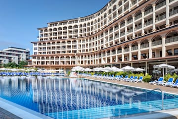 une piscine avec parasols et des chaises devant un immeuble