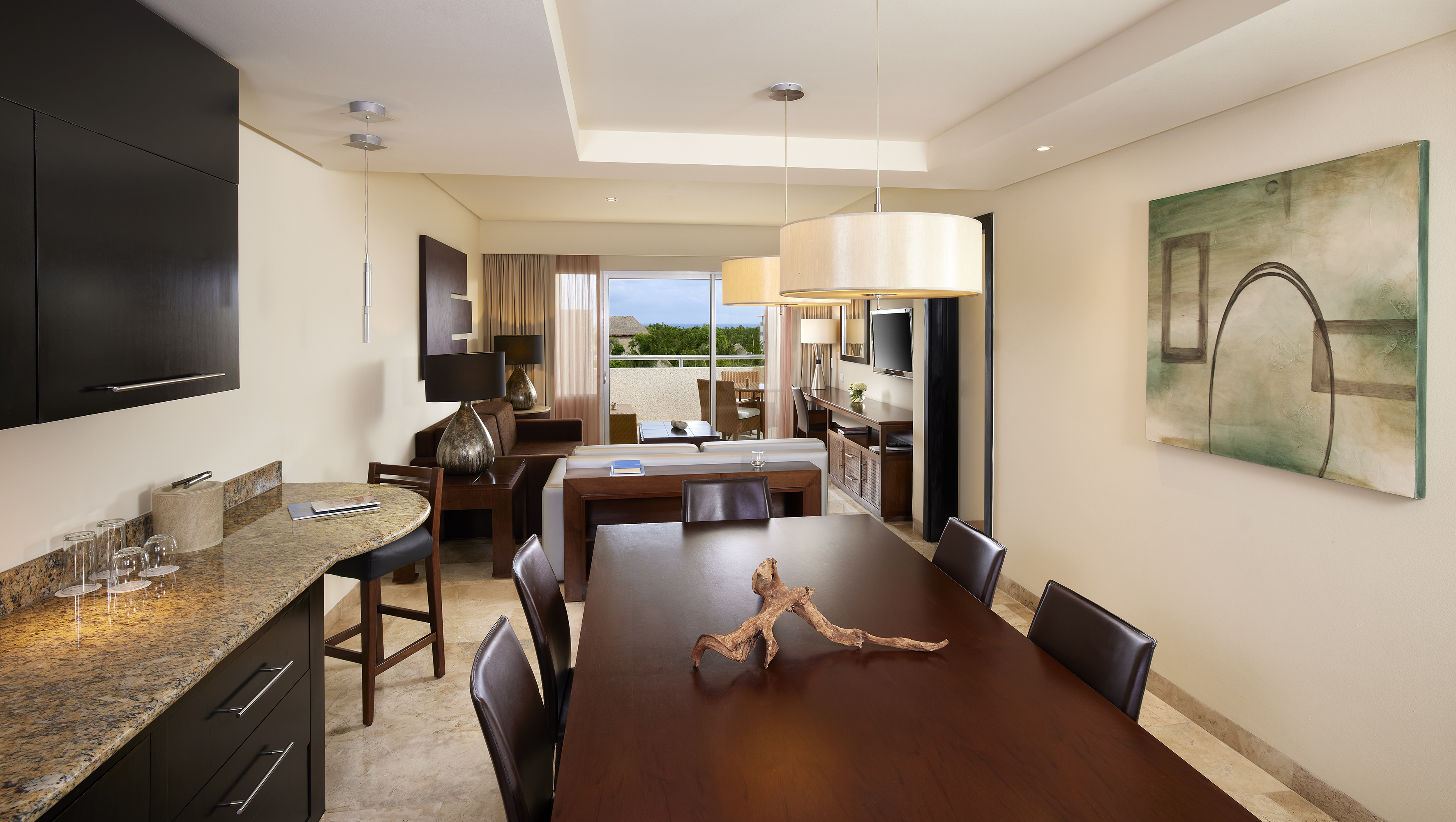 Modern luxury suite with dining, living, kitchen, and ocean view balcony.