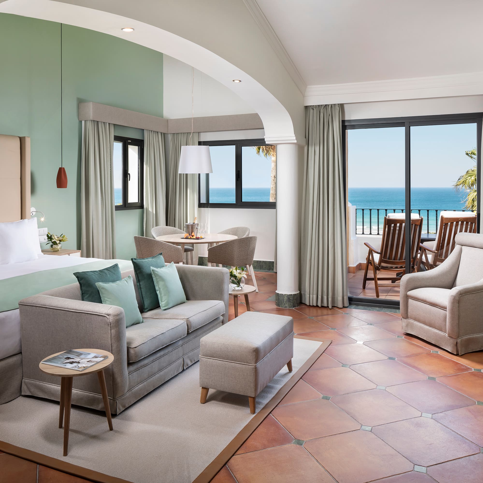 a room with a bed and a couch and chairs