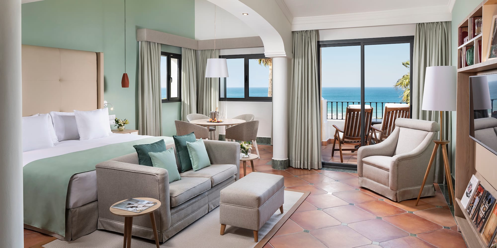 a room with a bed and a couch and chairs