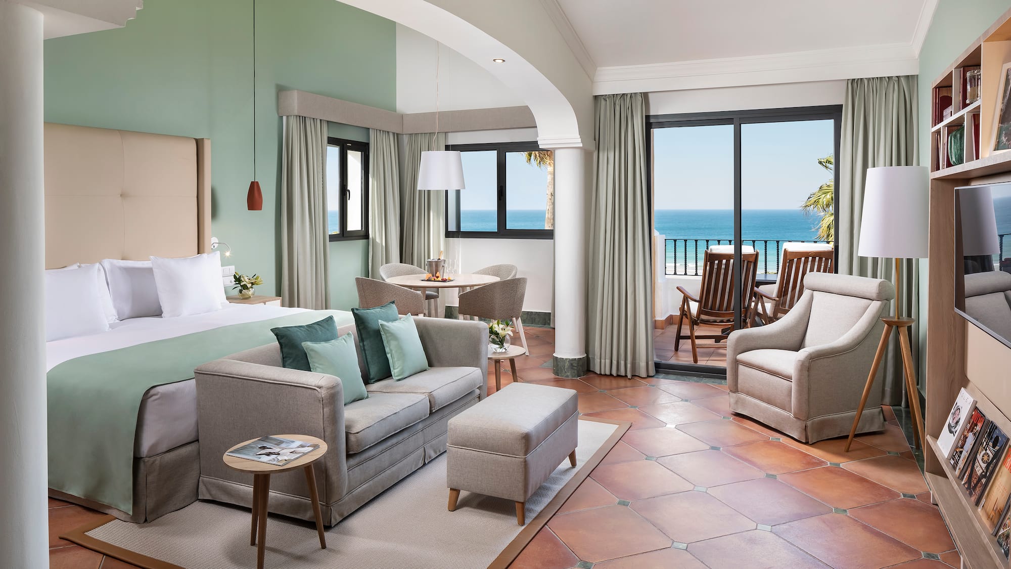 a room with a bed and a couch and chairs