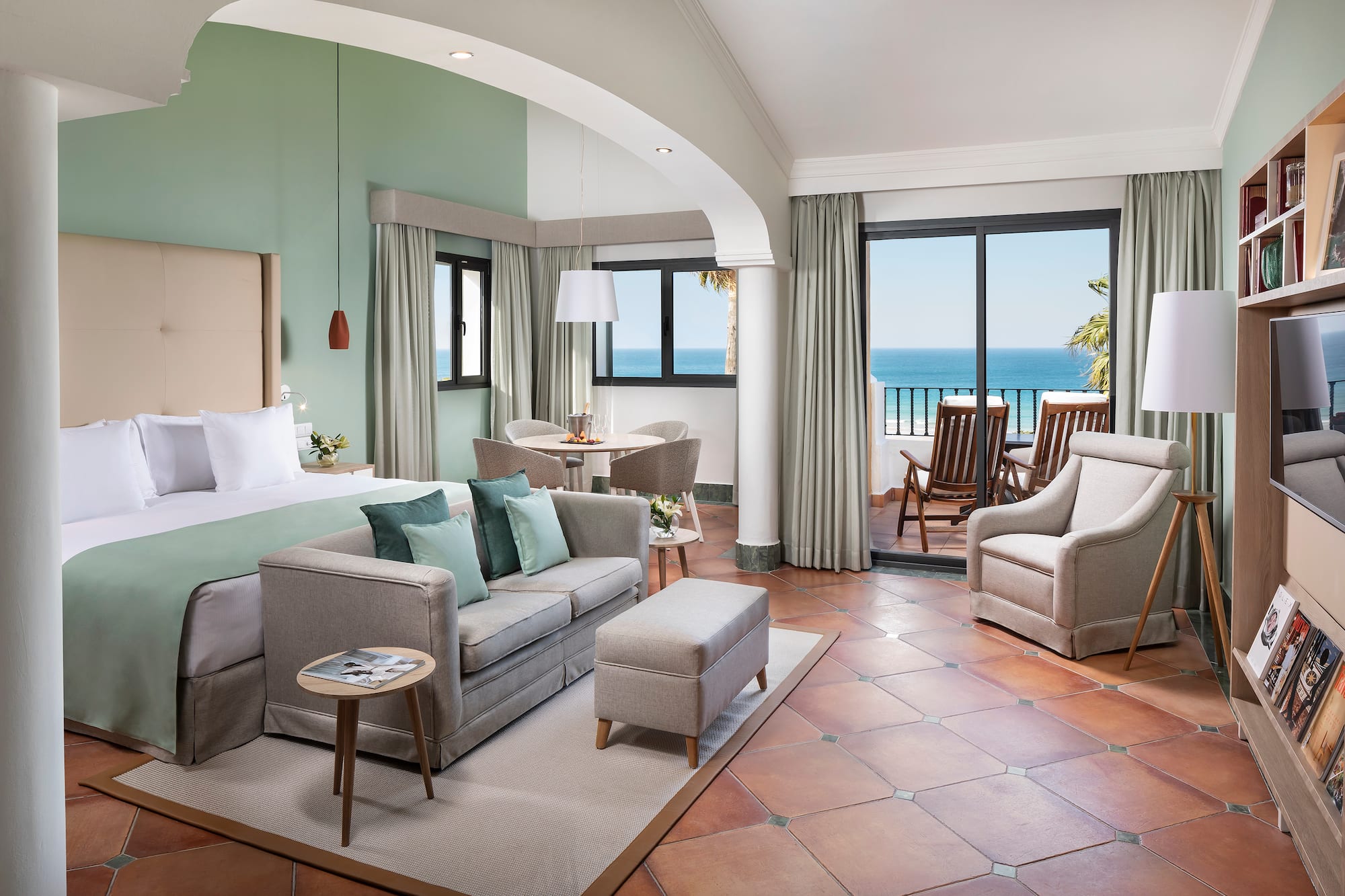 a room with a bed and a couch and chairs