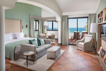 a room with a bed and a couch and chairs