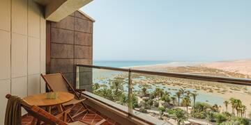 a balcony with chairs and a table