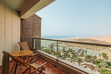 a balcony with chairs and a table