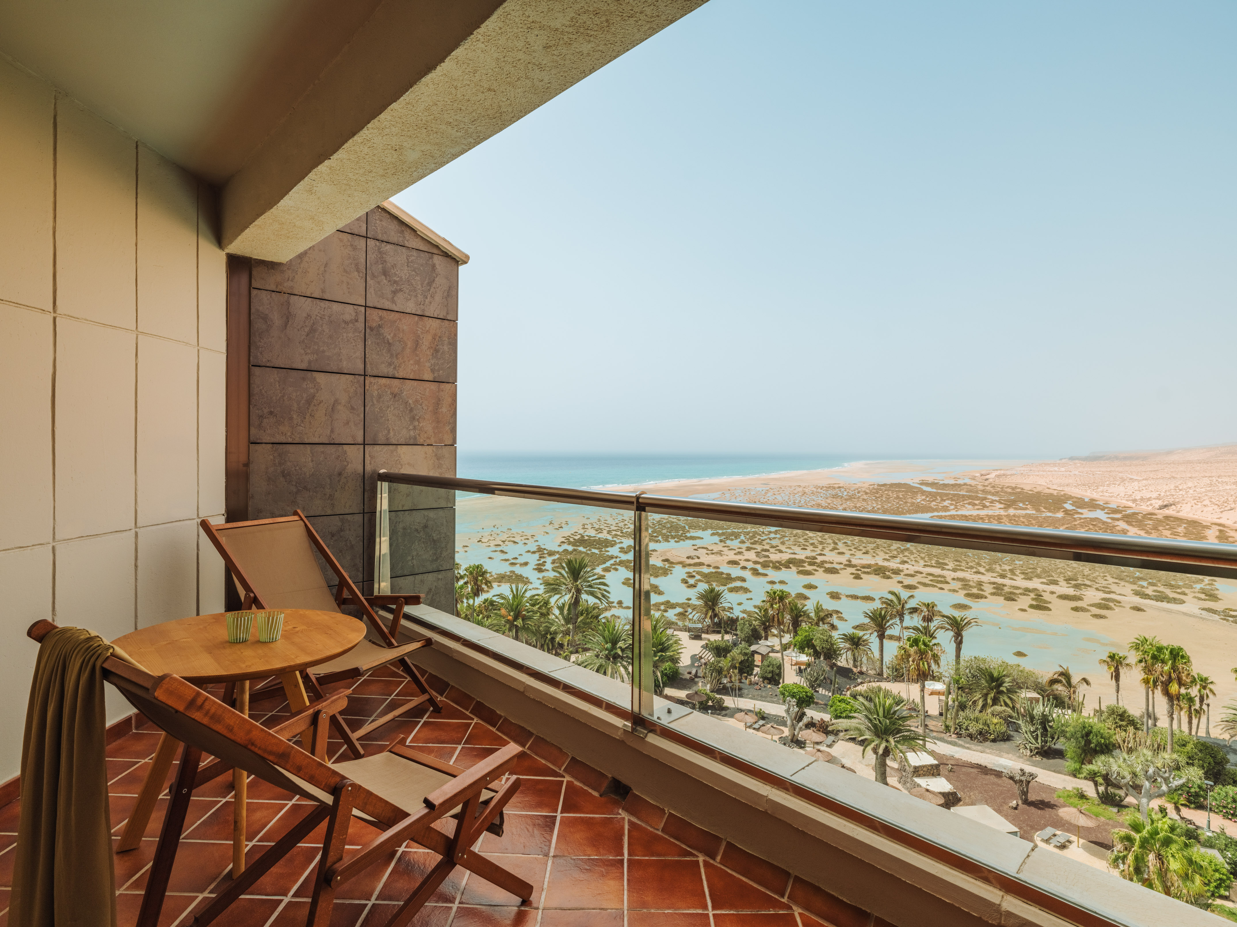 a balcony with chairs and a table