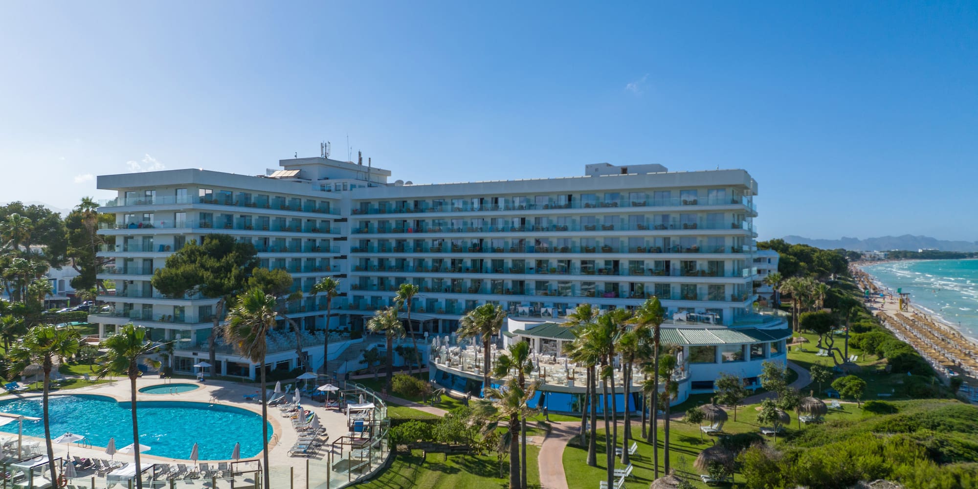 a large building with a pool and grass