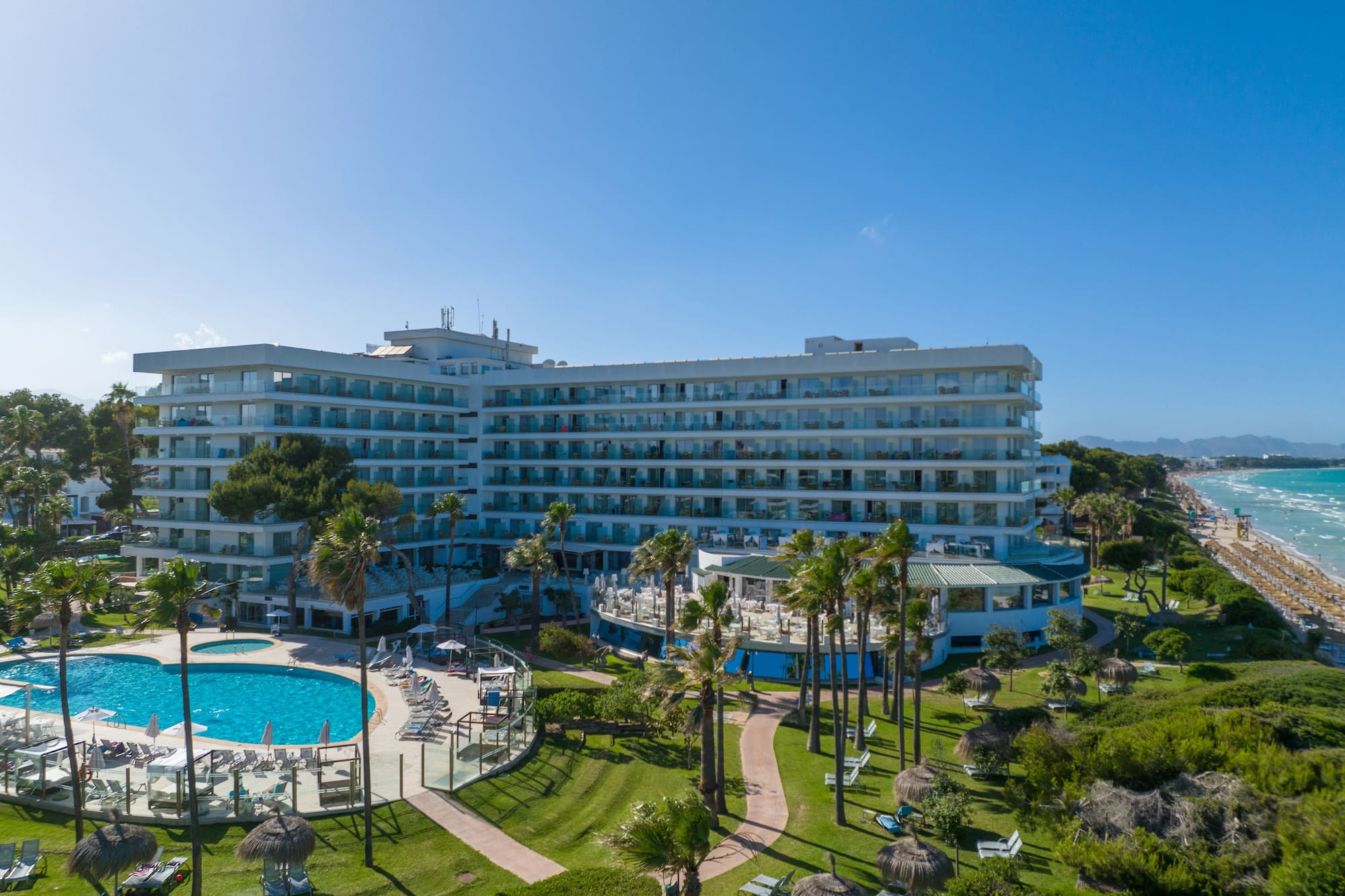 a large building with a pool and grass