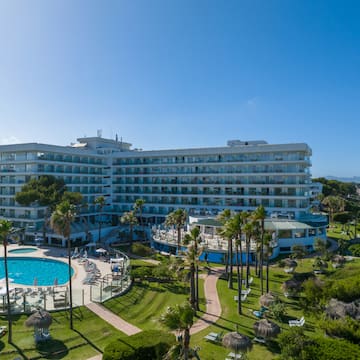 a large building with a pool and grass