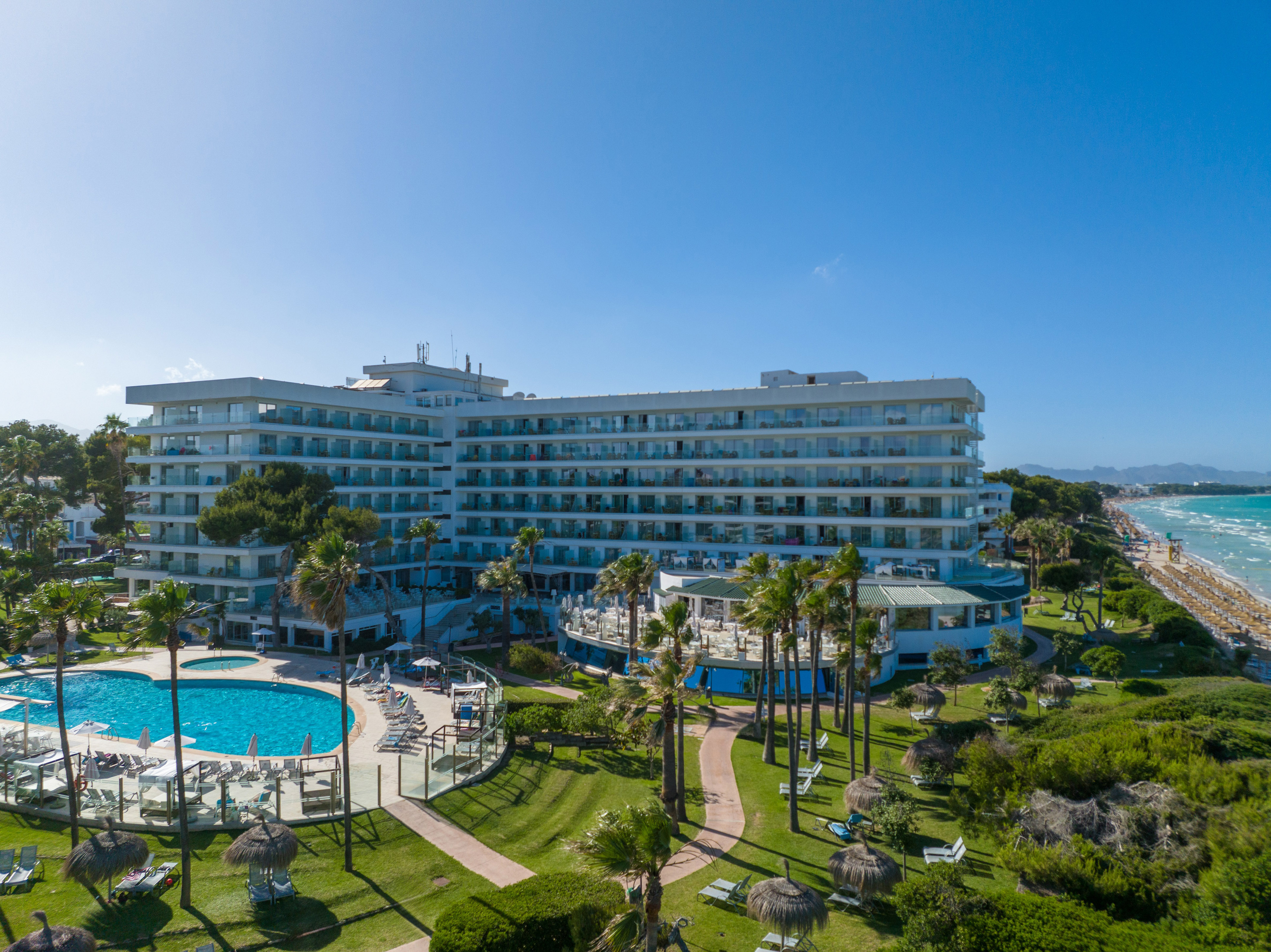 a large building with a pool and grass
