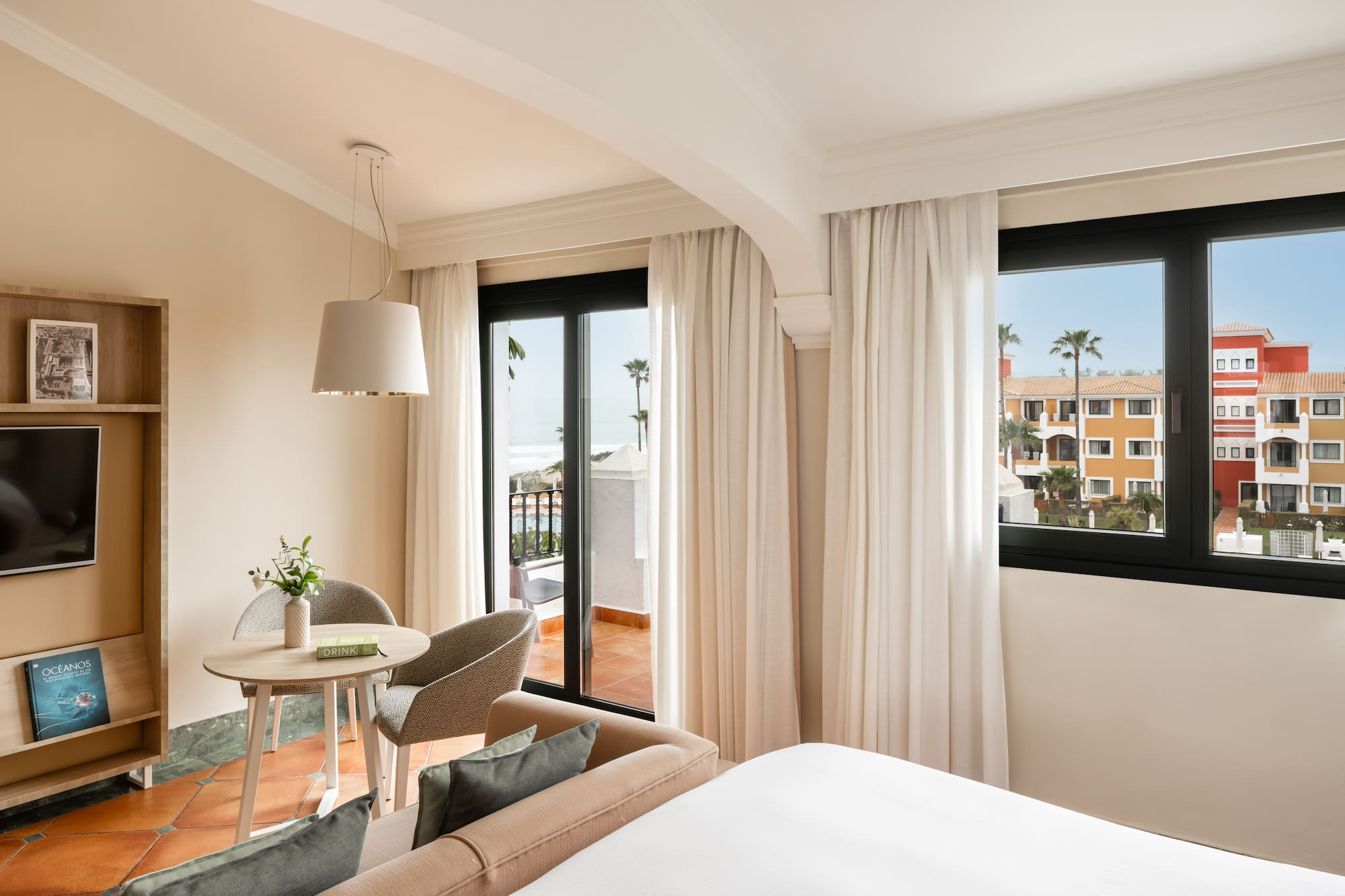 a room with a bed and a table and chairs