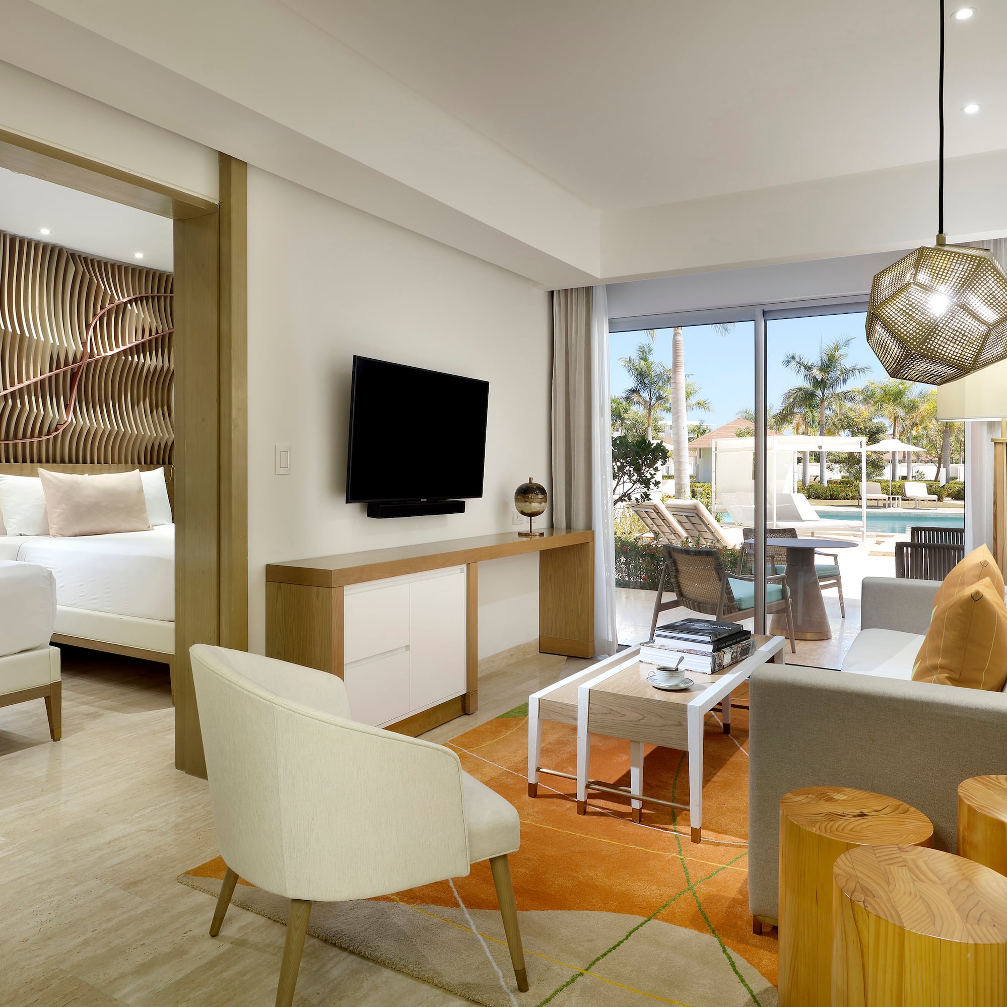 a room with a television and a pool in the background