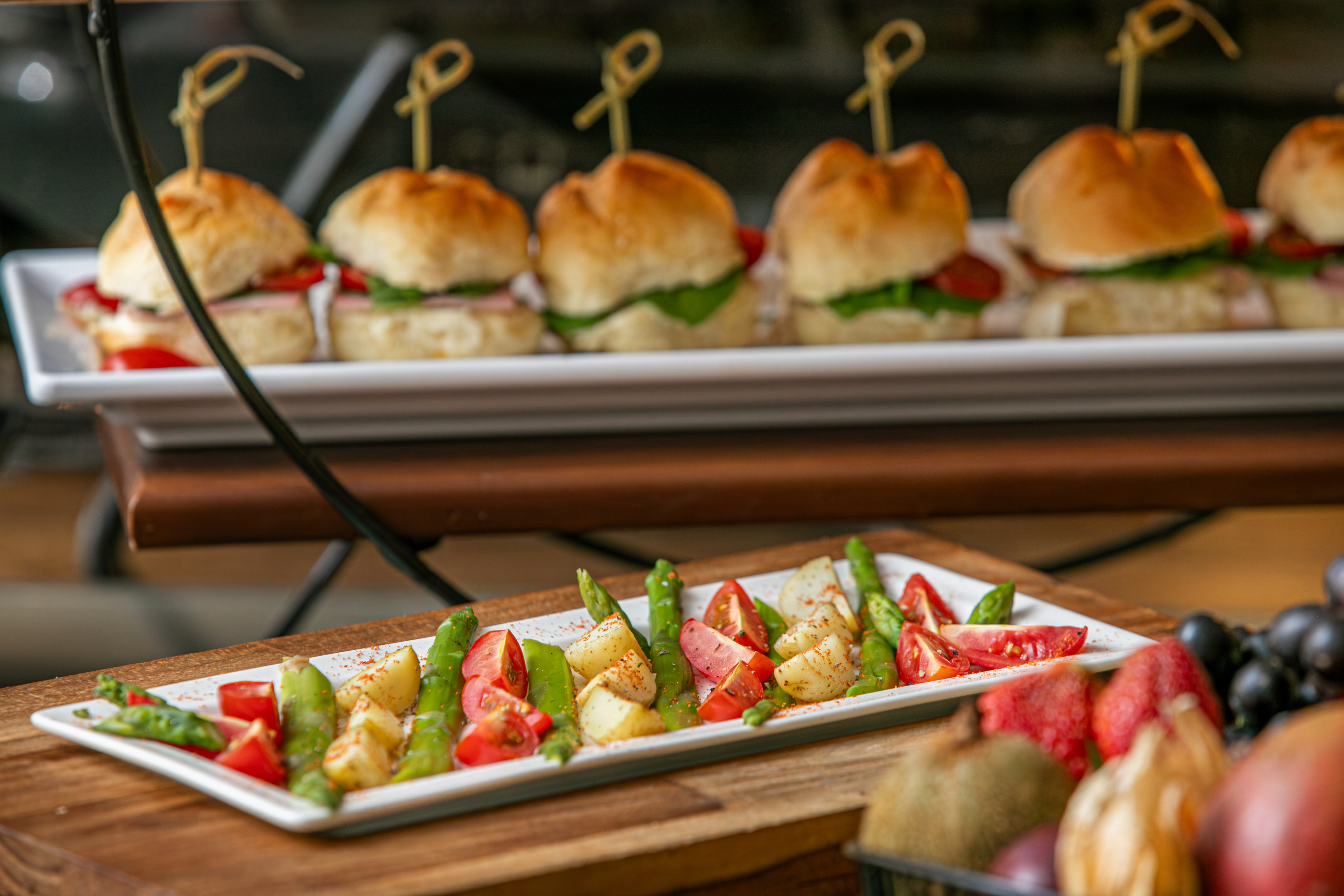 Mini sliders on tiered stand, with asparagus, potato, tomato salad.