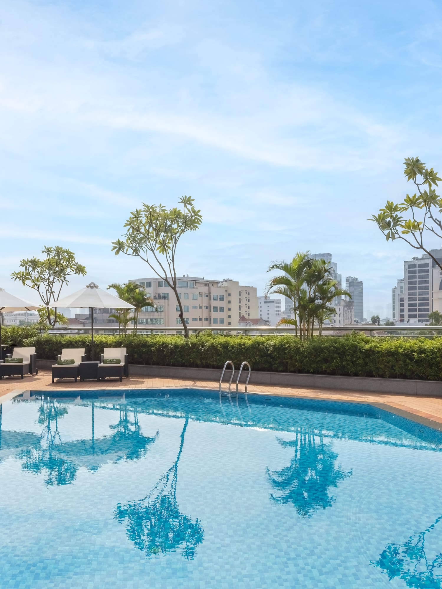a pool with chairs and umbrellas on a rooftop