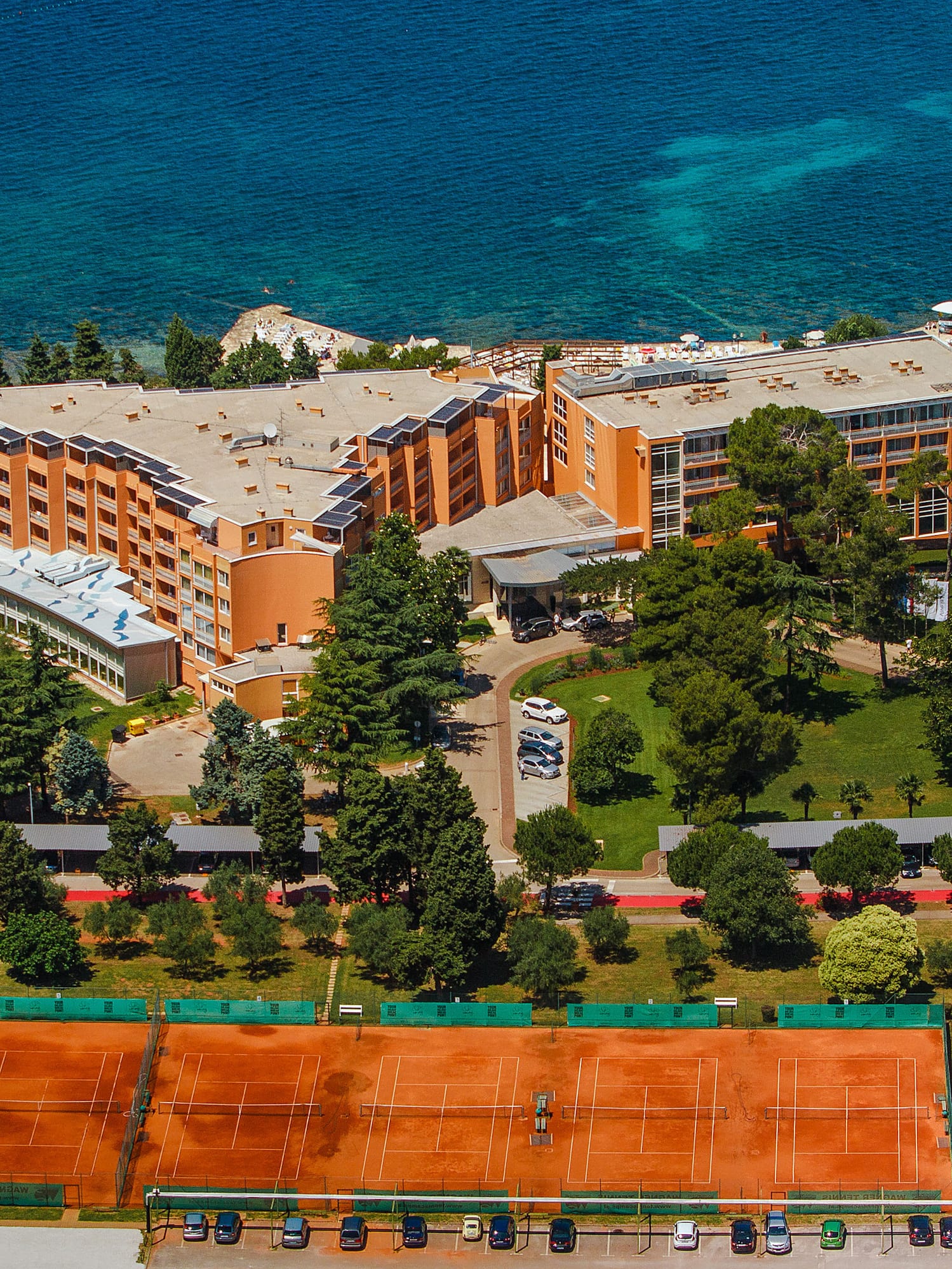a tennis court and a building by the water