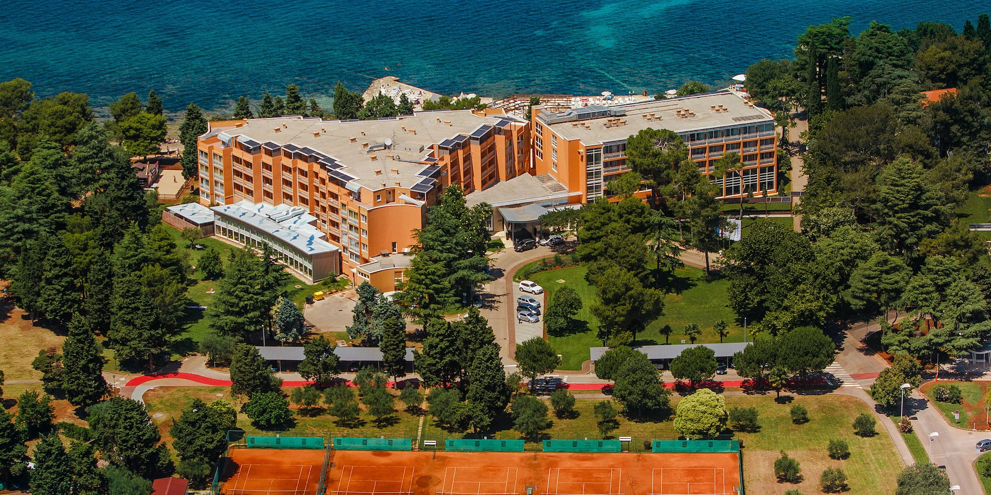 a tennis court and a building by the water