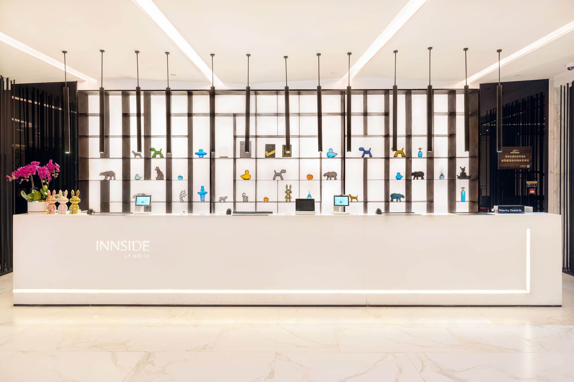 Innside by Melia front desk, modern lobby with animal figurines.
