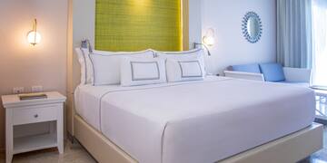 a bed with white sheets and pillows