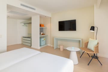 a room with two beds and a television