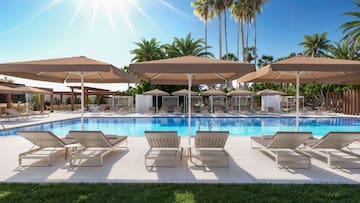a pool with lounge chairs and umbrellas