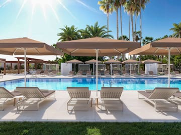 a pool with lounge chairs and umbrellas
