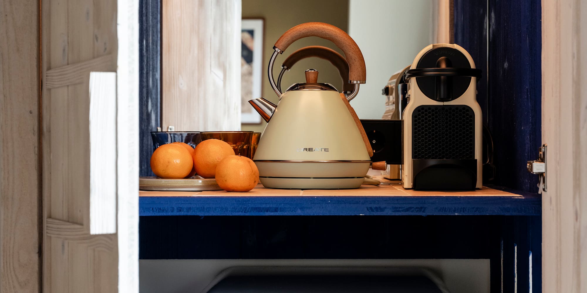 a kitchen cabinet with a white refrigerator and a tea kettle