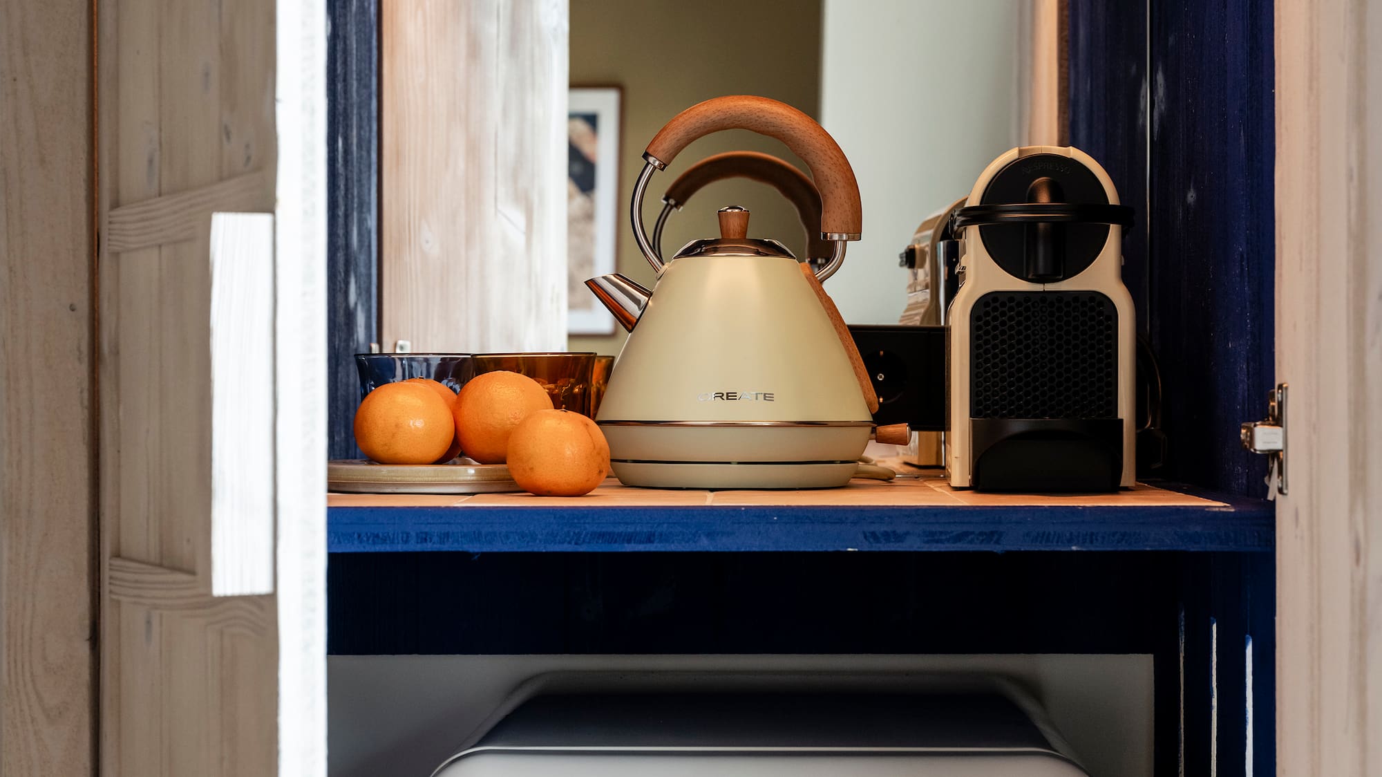 a kitchen cabinet with a white refrigerator and a tea kettle