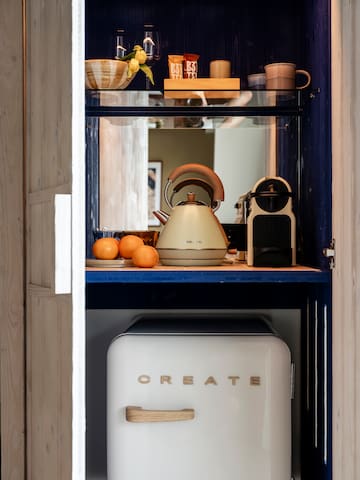 a kitchen cabinet with a white refrigerator and a kettle