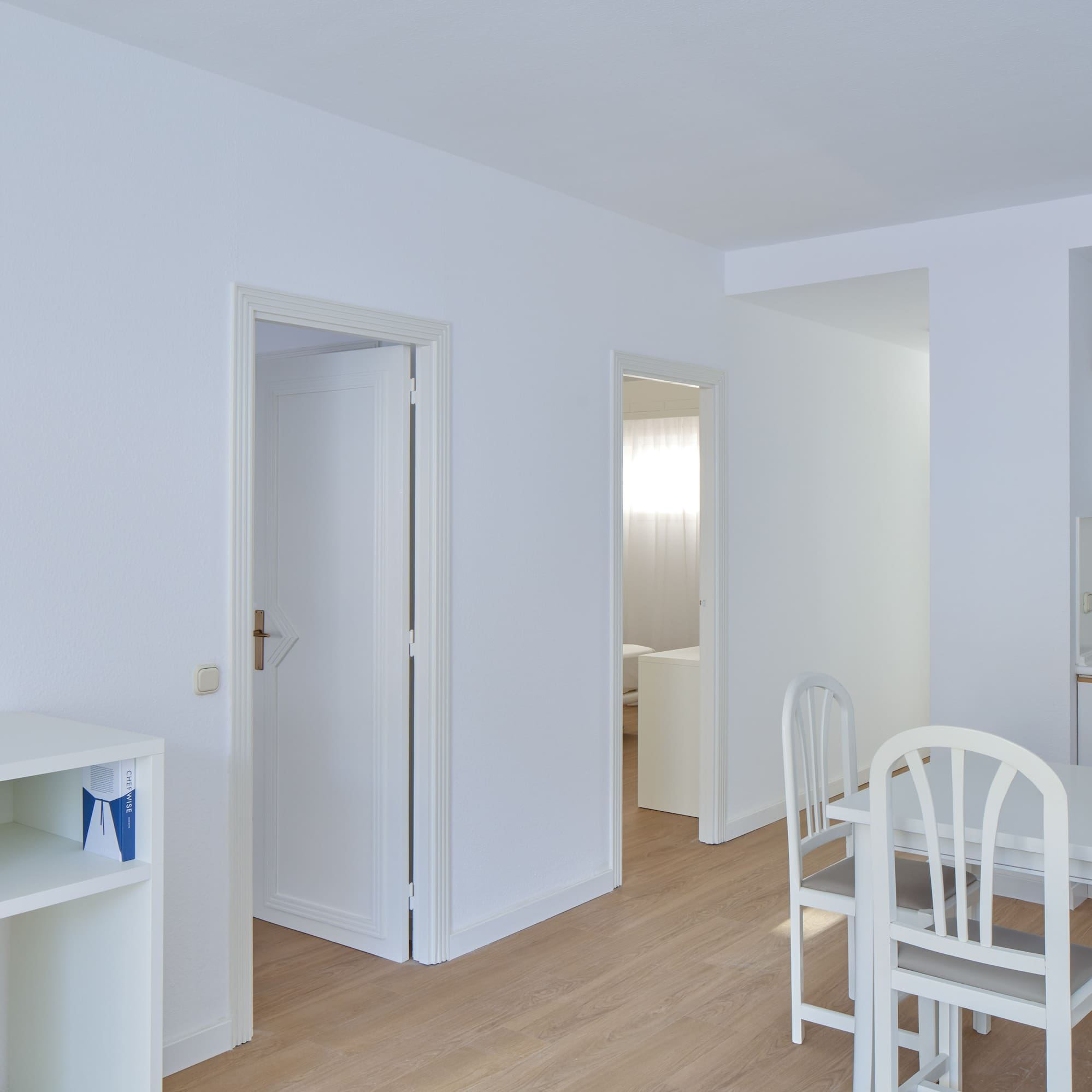 a room with white walls and a table and chairs