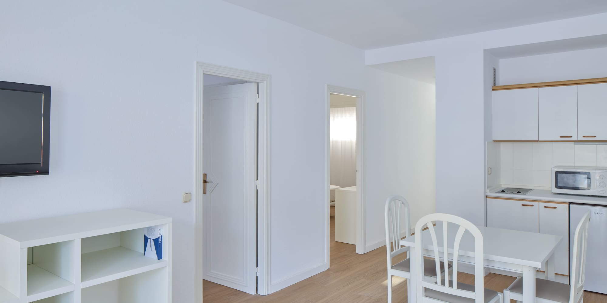 a room with white walls and a table and chairs