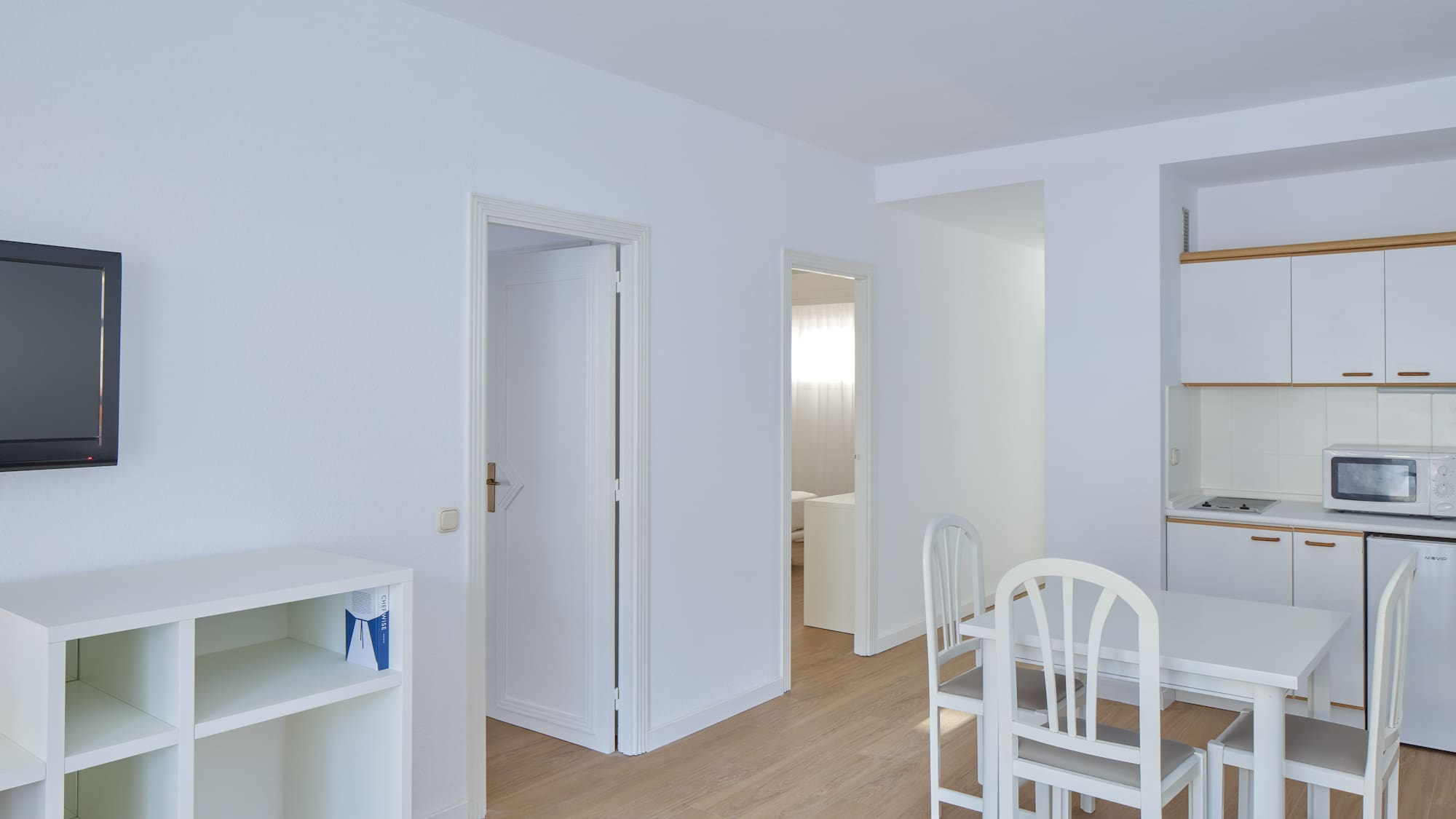a room with white walls and a table and chairs