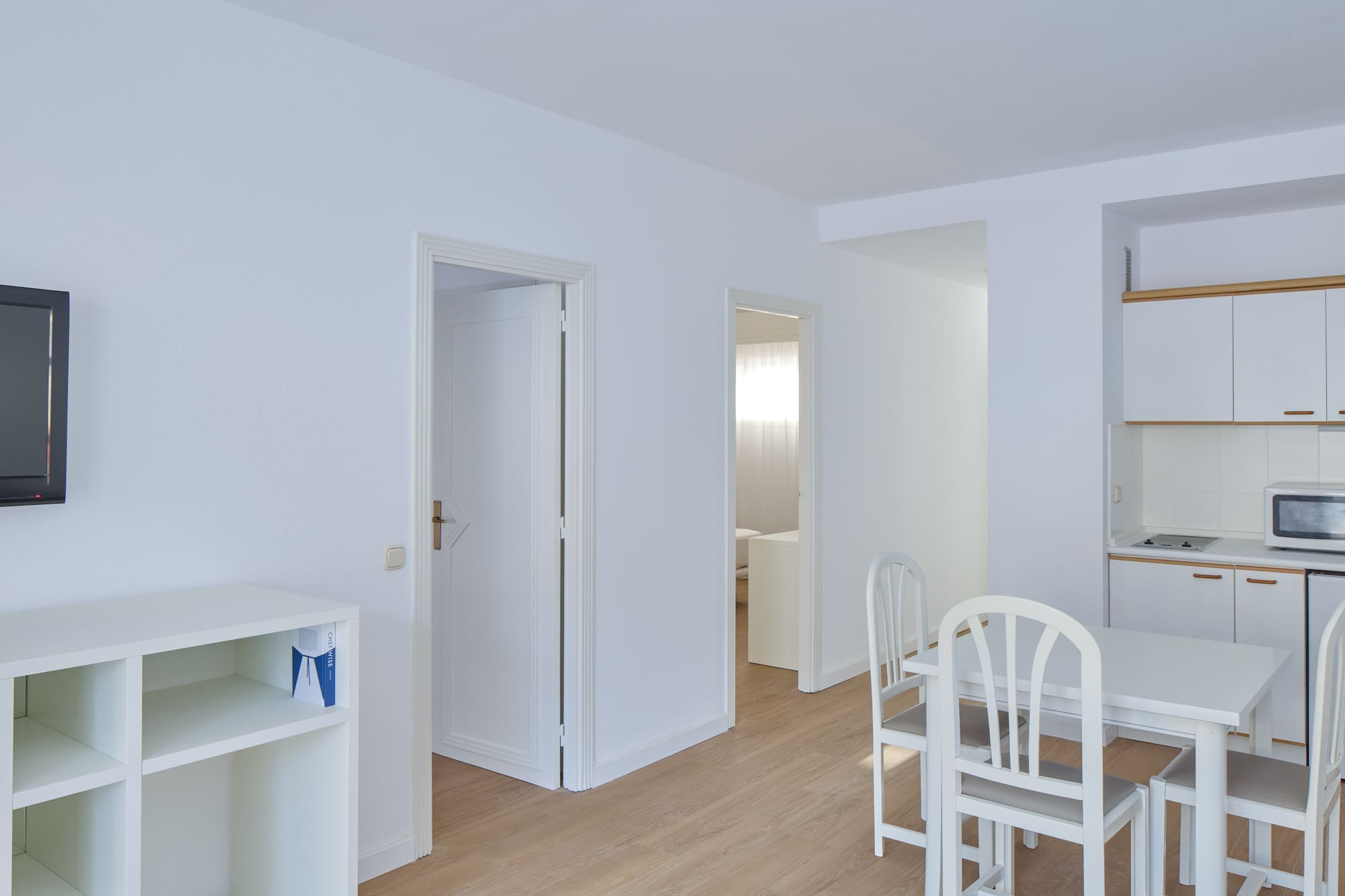 a room with white walls and a table and chairs