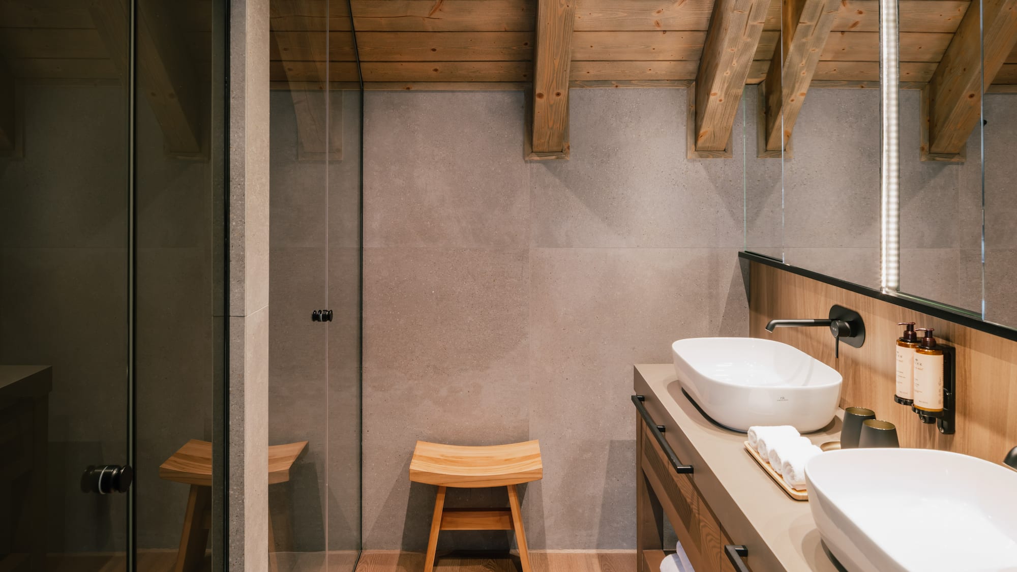 Modern bathroom: wooden beams, concrete walls, double vanity, glass shower.