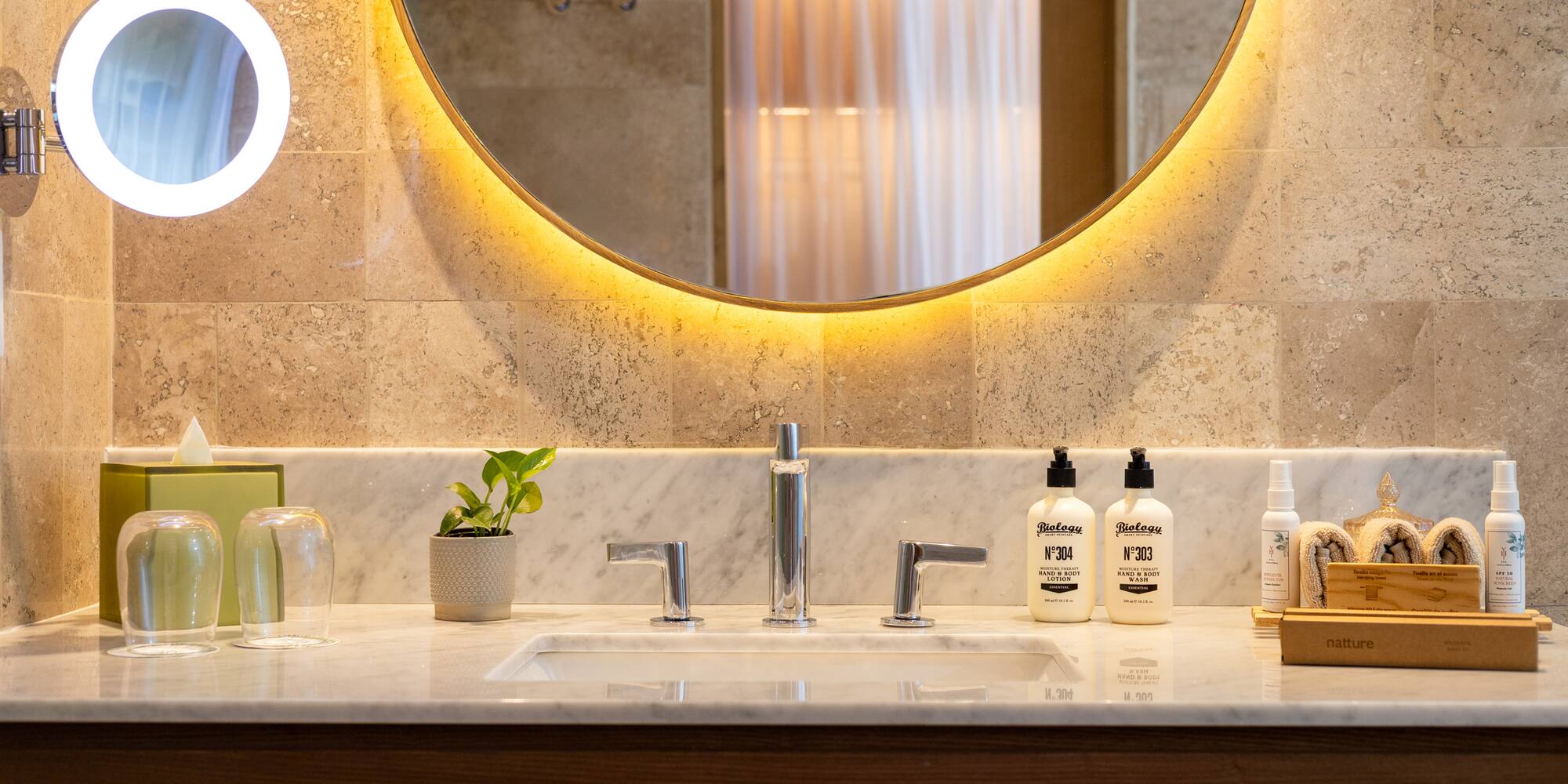 a bathroom sink with a round mirror