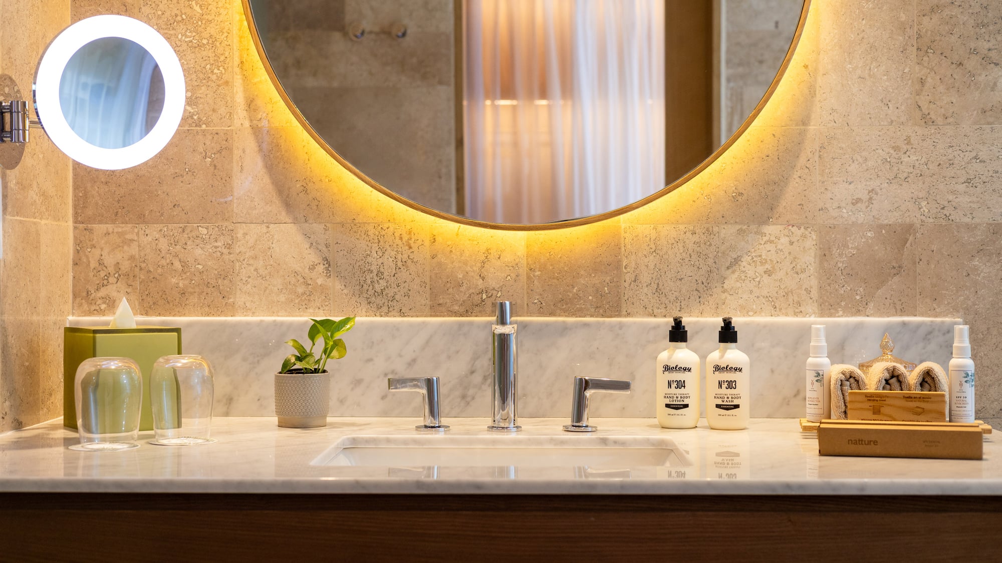 a bathroom sink with a round mirror