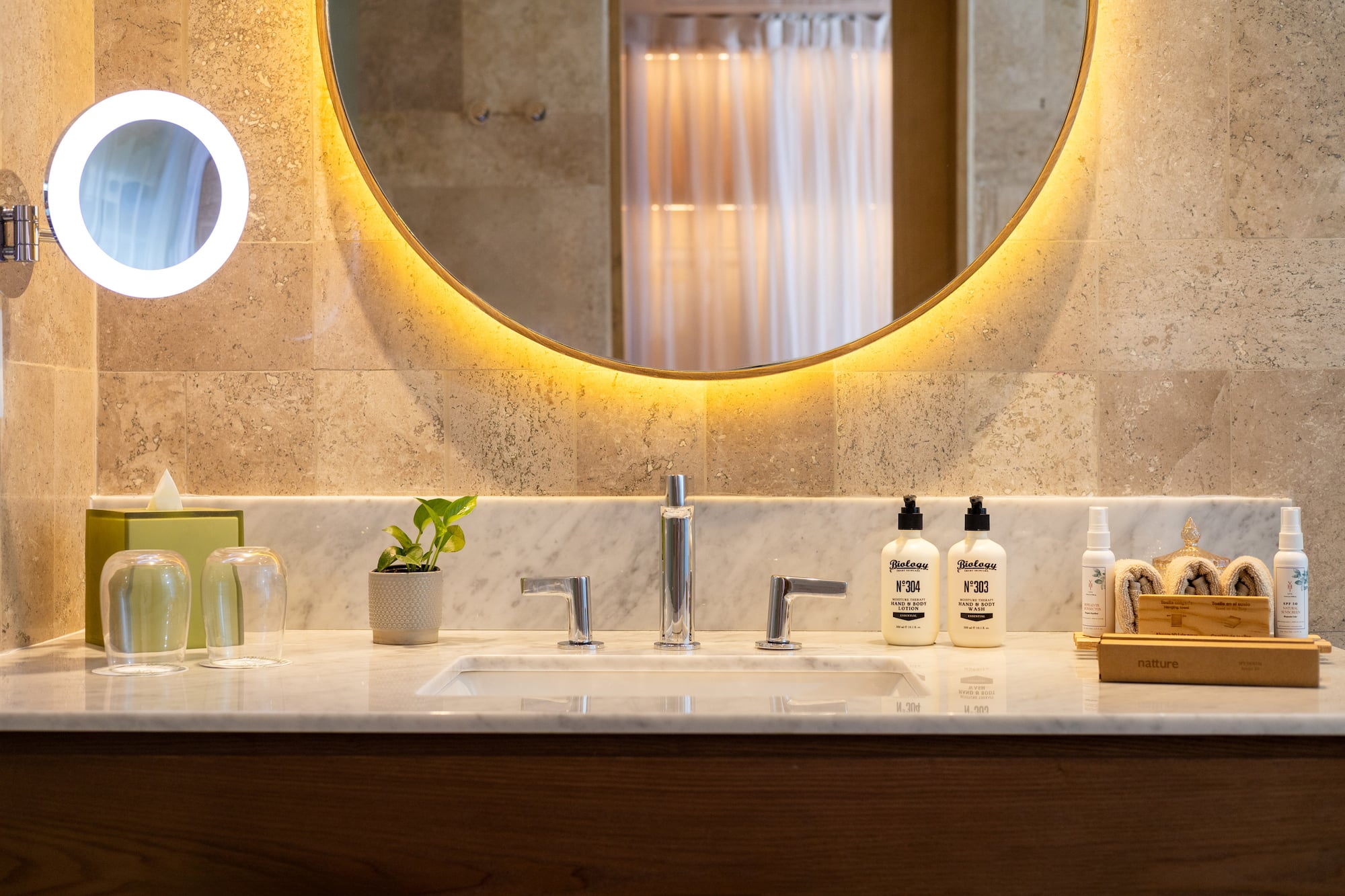 a bathroom sink with a round mirror