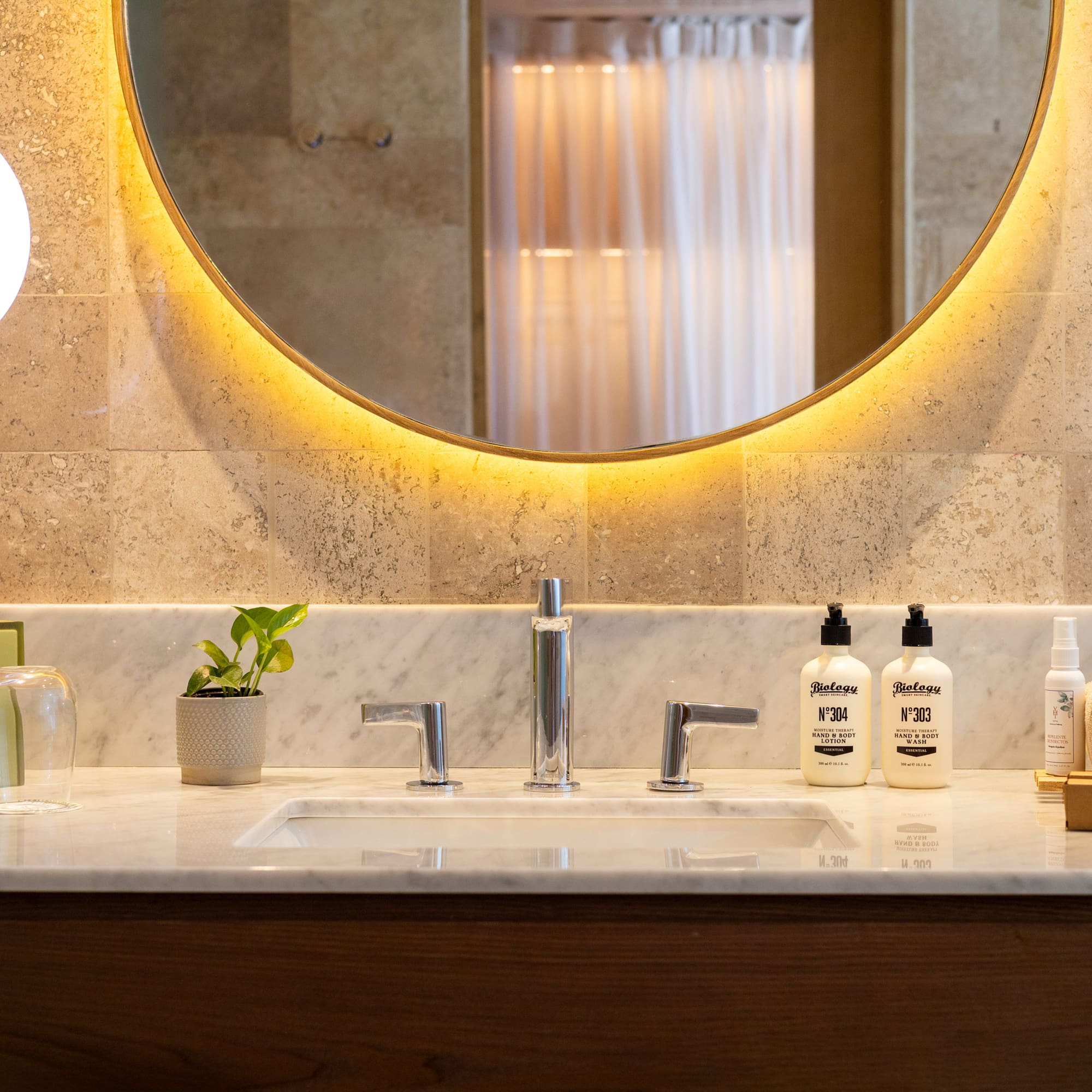 a bathroom sink with a round mirror