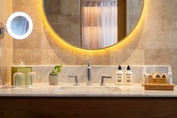 a bathroom sink with a round mirror