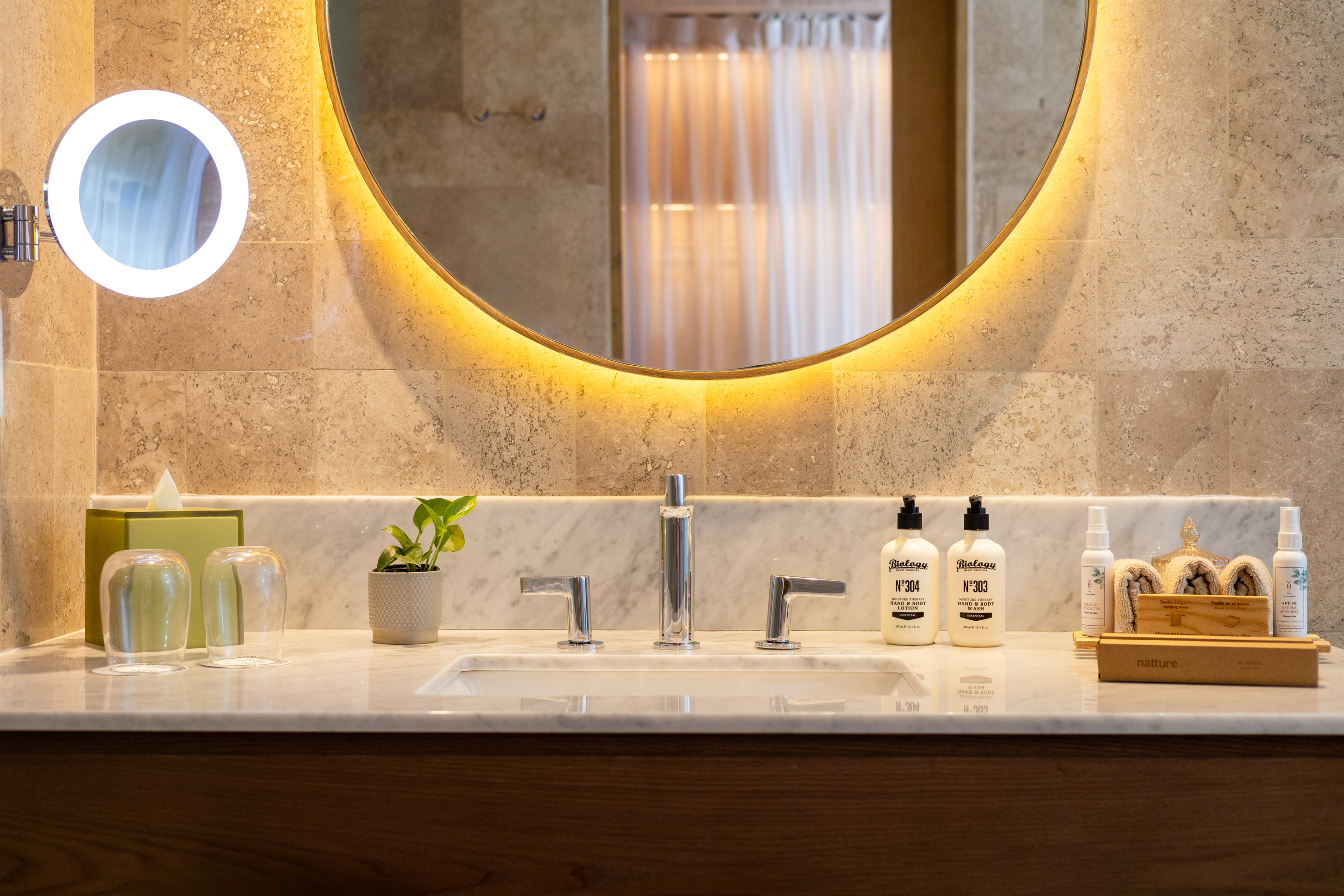 a bathroom sink with a round mirror