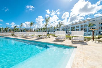 a pool with lounge chairs and a building in the background