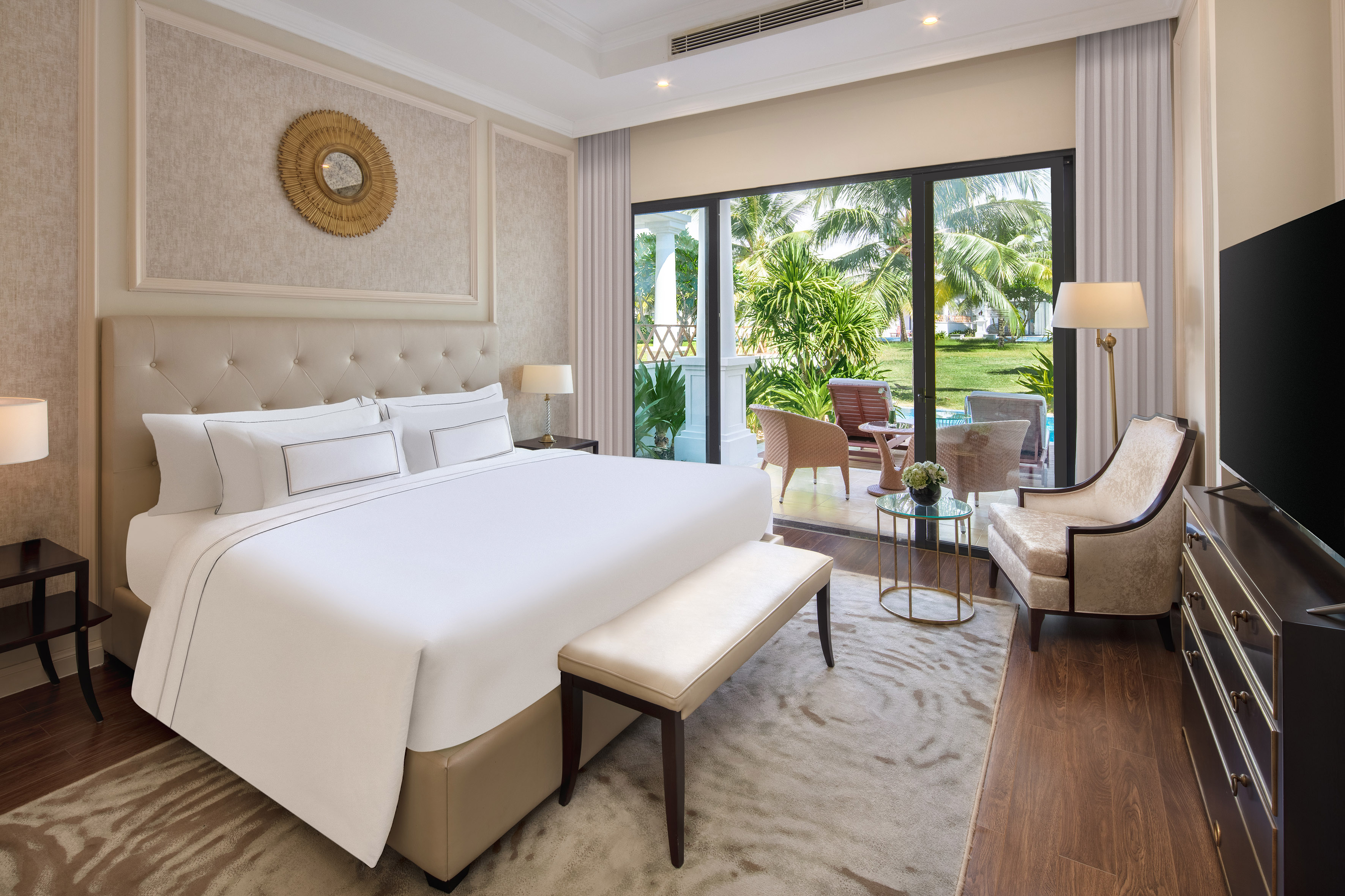 King bedroom in a luxury hotel with balcony and tropical garden view.
