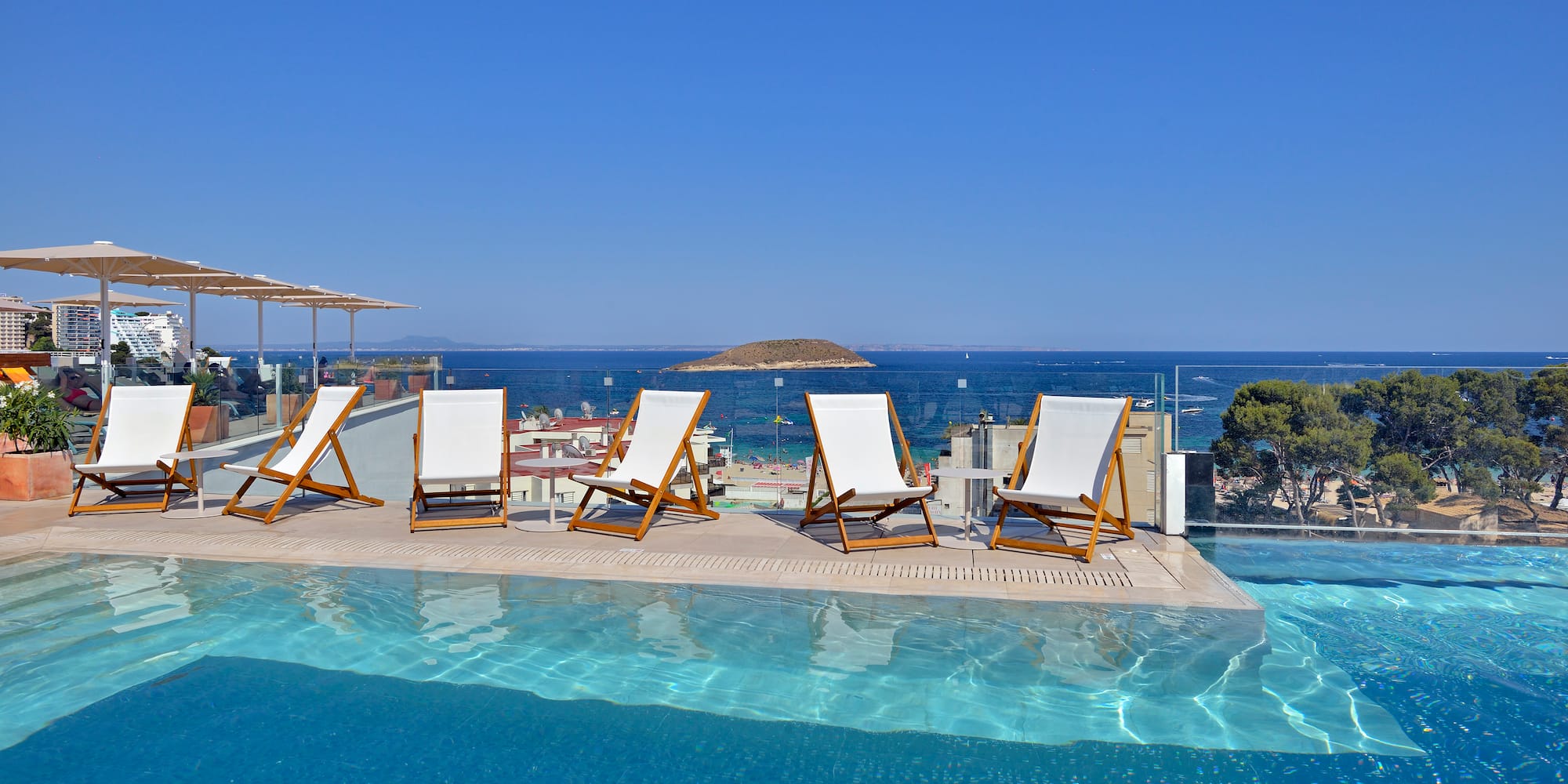 a pool with chairs and umbrellas on a sunny day