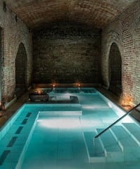 a indoor pool with a staircase and candles with Marrakesh in the background