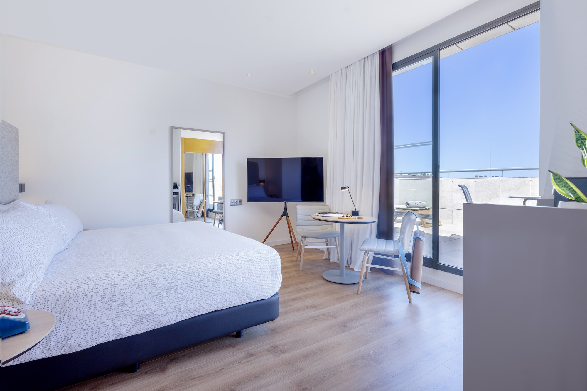 a bedroom with a large window and a bed